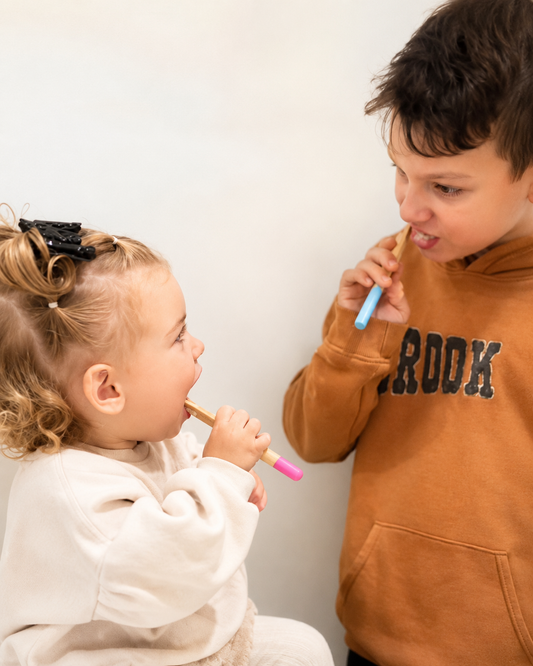 Younger sibling with older brother brushing teeth