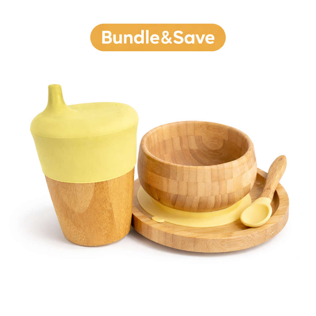 Yellow and wooden baby feeding set with a cup, bowl, and spoon on a white background.