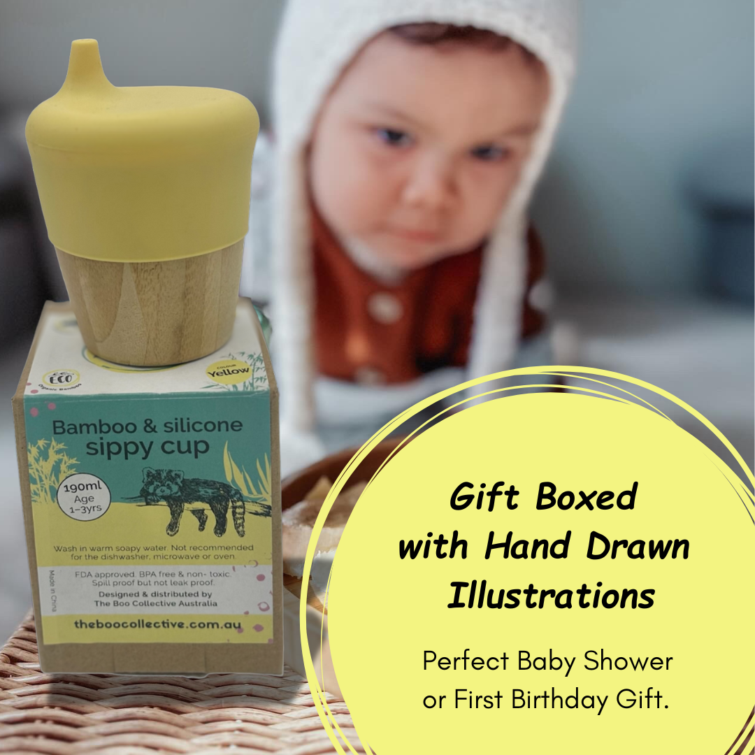 Bamboo and silicone sippy cup with packaging and a child in the background